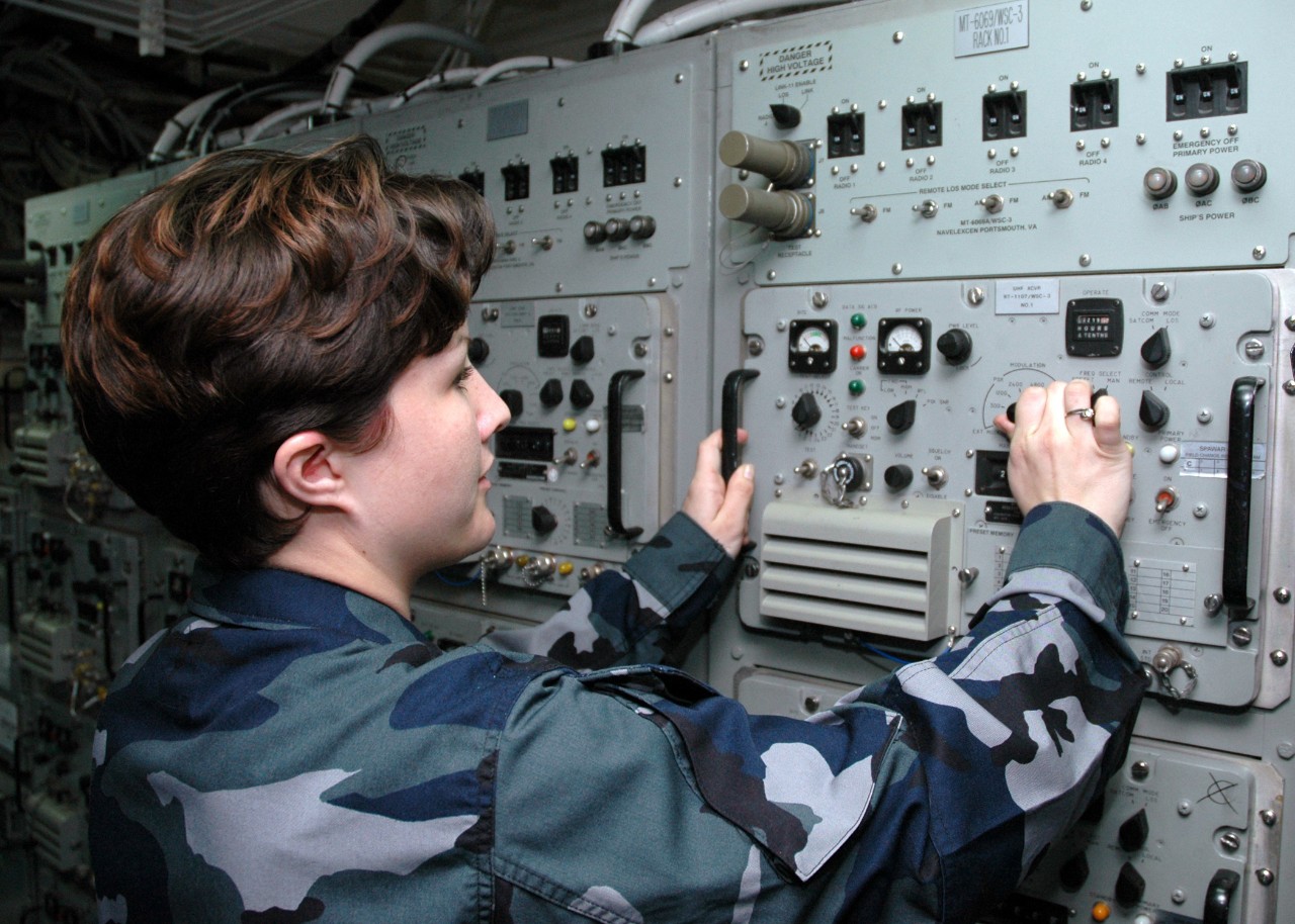 050208-N-7217H-013:    USS Tarawa (LHA-1), February 2005.    Aboard the amphibious assault ship USS Tarawa (LHA 1) at San Diego, California, Electronics Technician 2nd Class (SW) Heather Reul models the concept uniform while performing a routine inspection on the UHF satellite terminal (WCS-3), February 8, 2005.   The Navy will use four different concept uniforms. Each uniform offers a variety of options that Sailors will have the opportunity to choose from. Feedback from the Big T's selected sailors will be used to determine the final Navy Working Uniform. The Big T will be one of many test platforms used to determine the best uniform to replace current working uniforms.    Photographed by Photographer's Mate 1st Class Marvin Harris.   Official U.S. Navy photograph, now in the collections of the National Archives.   