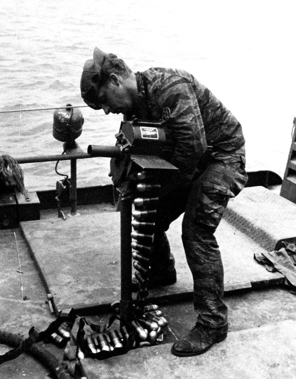 428-GX-USN 1139106:  Patrol Craft Fast (PCF), April 1969.    A U.S. Navy Inshore Patrol (PCF) crewman readies his Mk 18 Mod 0 Manual 40 mm grenade launcher for action during a patrol on the Ca Mau Peninsula River, Republic of Vietnam.  Photographed by PHC A.R. Hill, April 1969.  Official U.S. Navy photograph, now in the collections of the National Archives. 