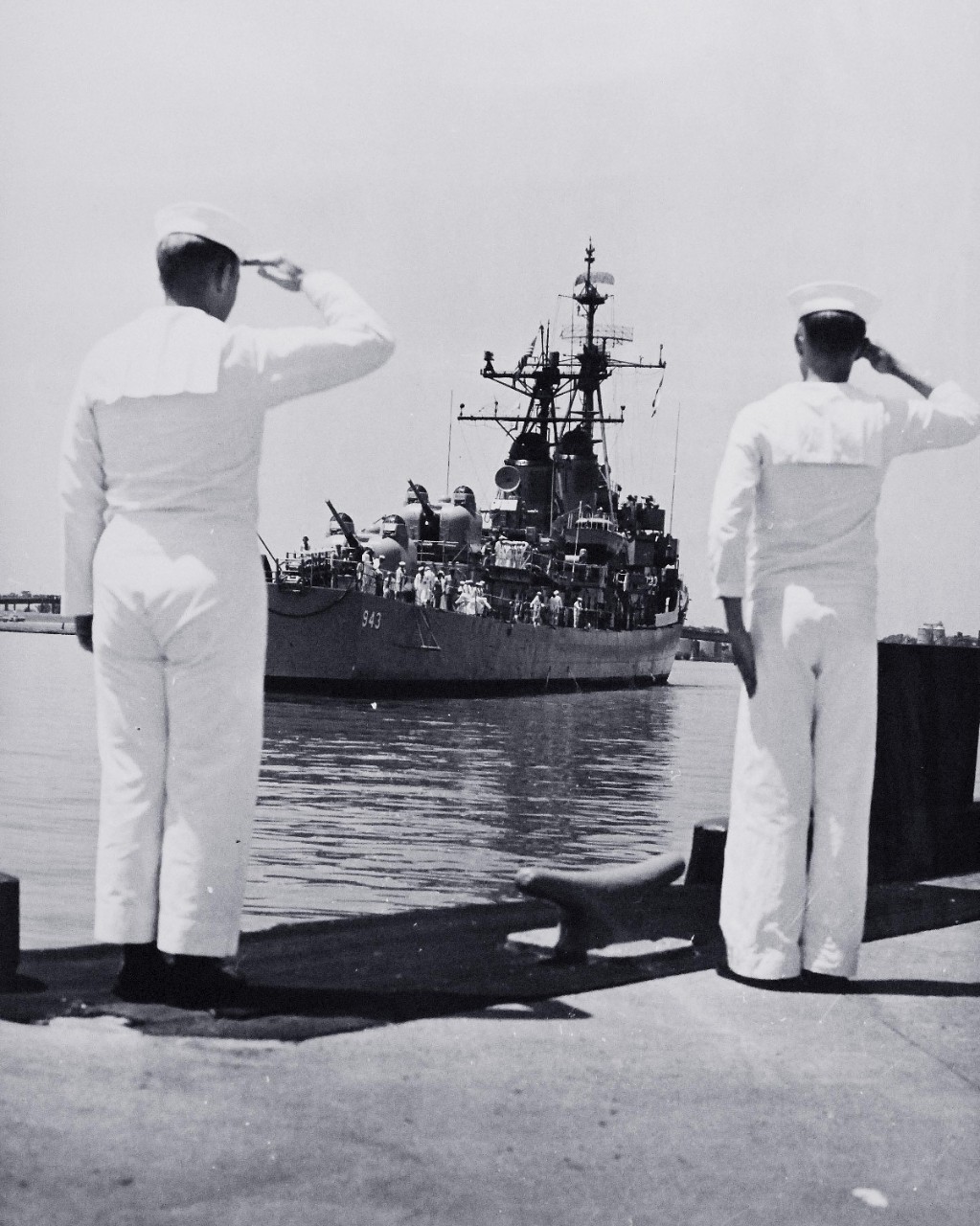 330-PS-8986 (111-SC-536401):    Unknown Servicemen of WWII and Korean War arrival at Washington Navy Yard, 1958.    Two U.S. Navy Sailors salute as USS Blandy (DD-943) arrives at the U.S. Naval Gun Factory (now Washington Navy Yard), Washington, D.C., with the remains of the Unknown Servicemen of World War II and the Korean War, May 27, 1958.  Official U.S. Army Photograph, now in the joint DOD Photograph Collection at the National Archives.   