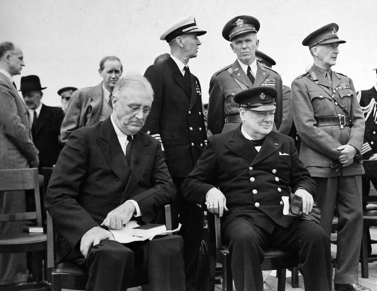 80-G-26867: Atlantic Charter, August 1941.  Informal group photograph including President Franklin D. Roosevelt and Prime Minister Winston S. Churchill on deck of HMS Prince of Wales following church services during the Atlantic Charter.  Left to right:  Harry Hopkins; Admiral Ernest J. King; General George C. Marshall and General Sir John Dill.  Photograph released August 1941.   Official U.S. Navy Photograph, now in the collections of the National Archives.  (2016/03/22).