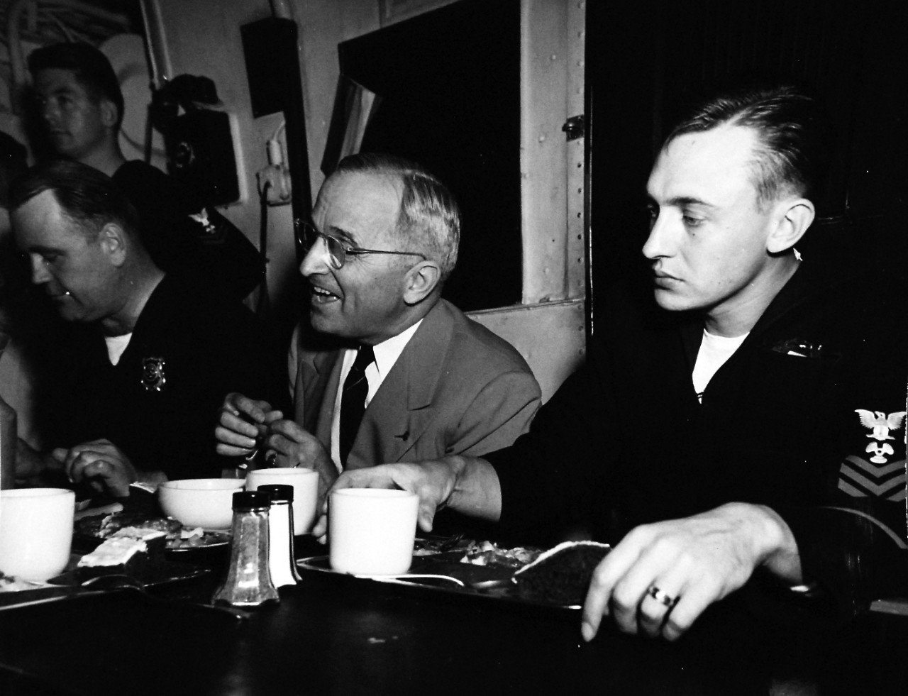 80-G-700298:   Potsdam Conference, July-August 1945.  President Harry S. Truman and party onboard USS Augusta (CA-31) for return voyage from the Potsdam Conference.  The President has chow with the crew:  Esmond J. Clifford, USNR (standing), George T. Fleming, USNR, the President, and J.C. Roaseau, USN.   Photograph released:  August 1945.  Official U.S. Navy photograph, now in the collections of the National Archives.  (2016/06/28).