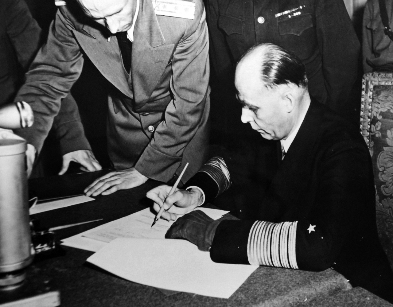 111-SC-27430:   Surrender of Germany, May 9, 1945.  General Admiral Hans-Georg Friedeburg, Commander in Chief of German Fleet, signs the ratified surrender of terms at Russian Headquarters in Berlin, Germany.  Photographed by Lieutenant Moore.   U.S. Army photograph.  Courtesy of the Library of Congress Collection, Lot-8988. (2015/10/16).