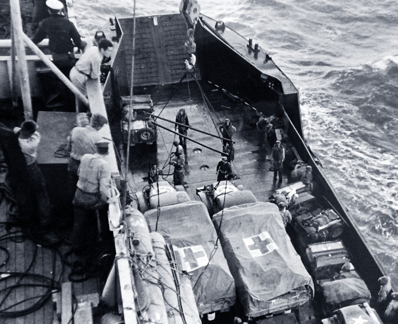 26-G-1978:  Operation Avalanche, September 1943.  Mercy Accompanies Invasions.  Following the invasion lines, mercy machines are lowered from a Coast Guard manned transport into an invasion craft for transportation to shore.  Coast Guardsmen handle the machines as carefully as if they already contained wounded.  The vehicles, plainly marked with the Red Cross, accompany the troops spearheading the attack against the Germans.   Official U.S. Coast Guard Photograph.   Courtesy of the Library of Congress: Lot-916. Photographed through Mylar sleeve. (2016/05/19). 