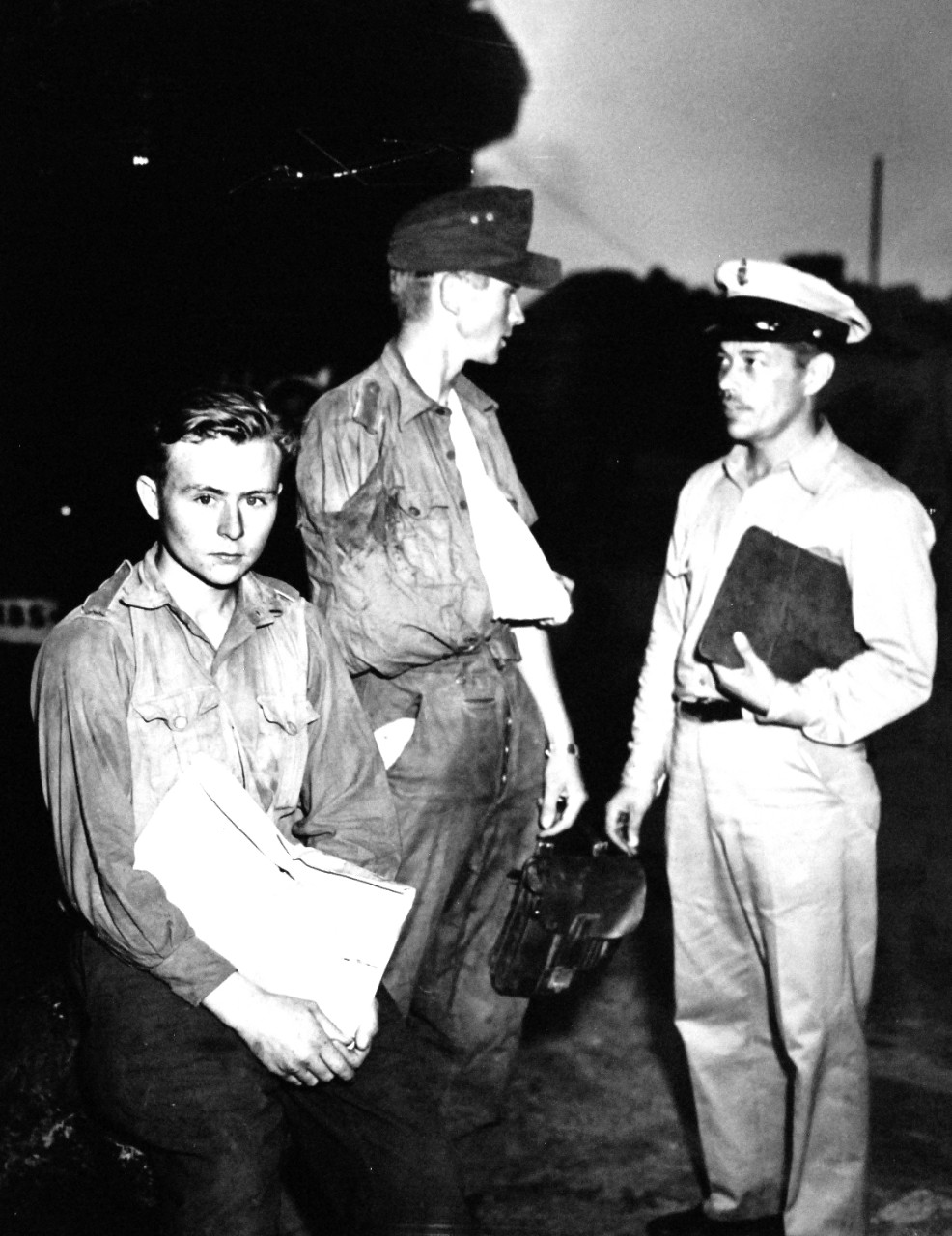 26-G-2046:  Operation Avalanche,  September 1943.  Coast Guardsman Talks It Over With Prisoners.  Somewhere in the Mediterranean, Coast Guardsman Earl Sauter talks to a wistful pair of young German prisoners onboard a Coast Guard manned transport en-route to a North African port.  The Germans were captured in the fighting around Salerno.  Coast Guardsman Sauter is a Chief Pharmacist’s Mate.     Official U.S. Coast Guard Photograph, now in the collections of the National Archives.   (2015/5/19). 
