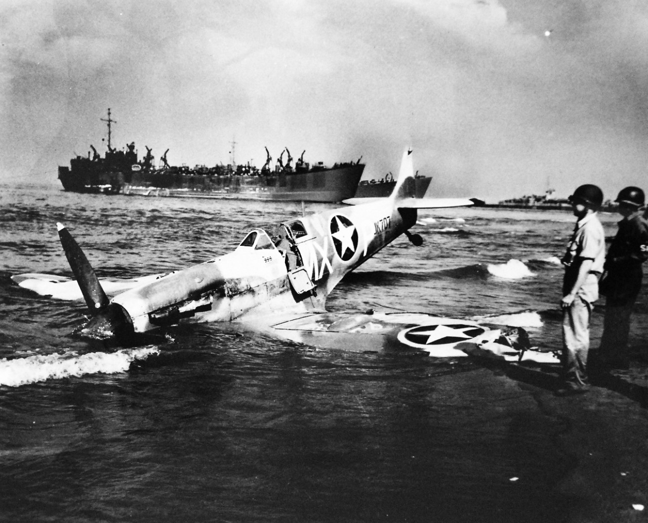LC-Lot-916-2:   Operation Avalanche, September 1943.  Forced Landing On Invasion Beach.  Combat ended with a forced landing on the beach at Paestum, Italy, for this Spitfire being examined by U.S. Coast Guardsman and soldier.  Note, the three swastikas painted on the cockpit of the plane.  U.S. Coast Guardsmen manned combat transports and landing craft, one of which appears in the background.    Official Coast Guard Photograph. Photographed through Mylar sleeve.   Courtesy of the Library of Congress.  (2016/05/19).