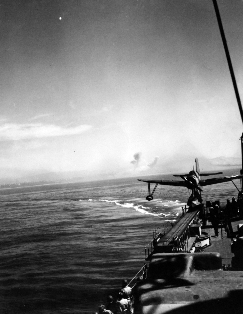 80-G-74832:   Operation Husky, July-August 1943.   Bombing of the coast of Gela, Sicily, by the Germans, as seen from the deck of USS Boise (CL-47).  Note the OS2U on the catapult.    Photographed by USS Boise (CL-47), July 10 1943.    Official U.S. Navy Photograph, now in the collections of the National Archives.  (2018/02/14).    