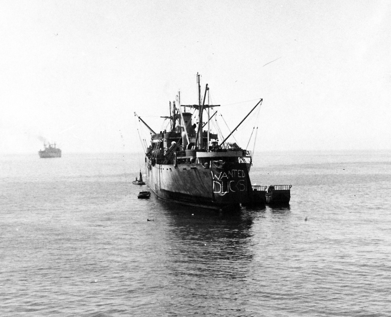 80-G-86223:  Operation Husky, July-August 1943.  Liberty ship in Gela Harbor unloading into LCM’s during the invasion of Sicily.    Note the sign that reads, “Wanted Ducks”.   Photograph received July 15, 1943.      U.S. Navy Photograph, now in the collections of the National Archives.  (2017/01/17).