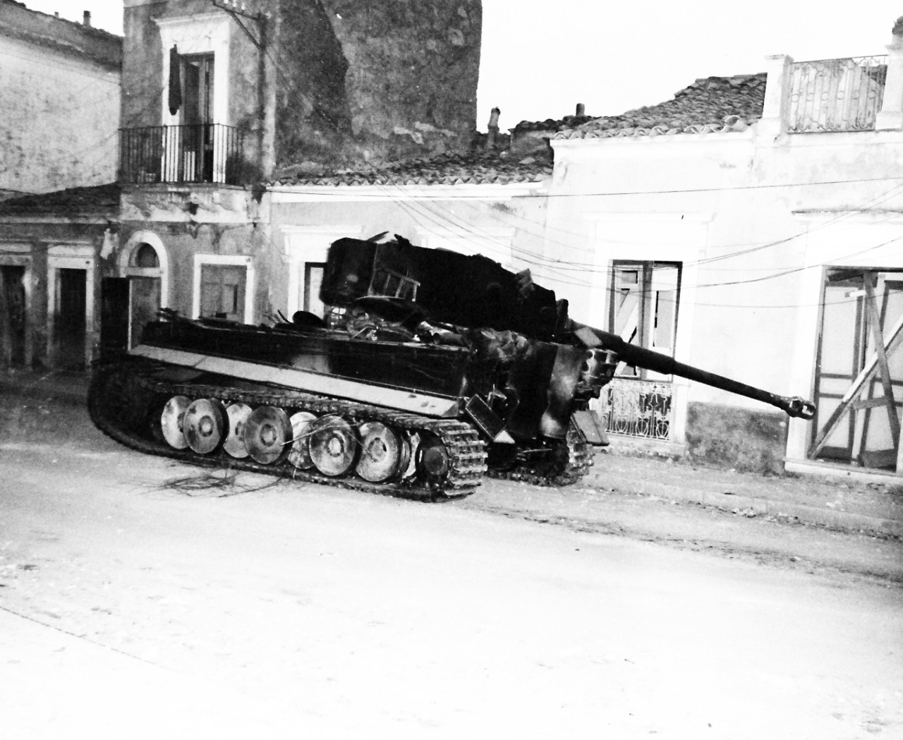 80-G-86226:  Operation Husky, July-August 1943.  Battle damage shown after successful landing operations by the Allies in the invasion of Sicily.  Note: Wreckage of German Mark VI tank at Biscari.     Photograph received July 14, 1943.      U.S. Navy Photograph, now in the collections of the National Archives.  (2017/01/17).