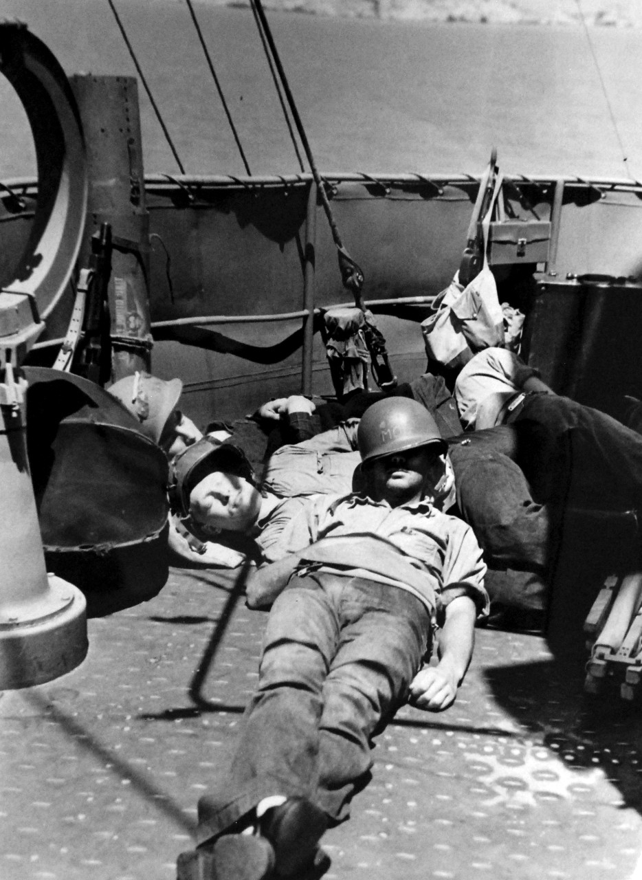 Operation Husky, July-August 1943. Cat-Nap!  Their ship is nosing into Sicilian shore and soon they must spring into action…but these American servicemen have learned the veteran’s facility for relaxing right-up until the call to “fall in.”   Photograph released August 3, 1943.  Photographed through Mylar sleeve. U.S. Navy Photograph. Courtesy of the Library of Congress.  (2015/10/30).