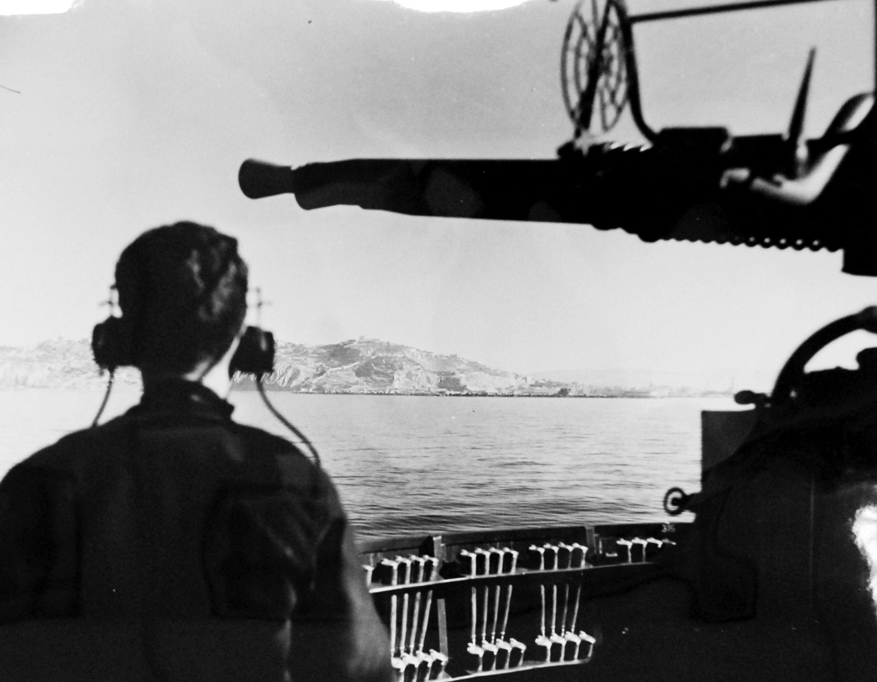 LC-Lot-805-40: Operation Husky - Invasion of Sicily, July-August 1943. Licata Comes Within Range.  Framed by the death-dealing barrels of a dual-purpose 20mm gun aboard a destroyer and the silhouette of an observer, the city of Licata, Sicily, Italy, comes within easy range of an American destroyer.  It was “Invasion Day” and the destroyer was but one of the great armada of ships.   Photograph released July 29, 1943.  Photographed through Mylar sleeve. U.S. Navy Photograph.  Courtesy of the Library of Congress.  (2015/10/30).