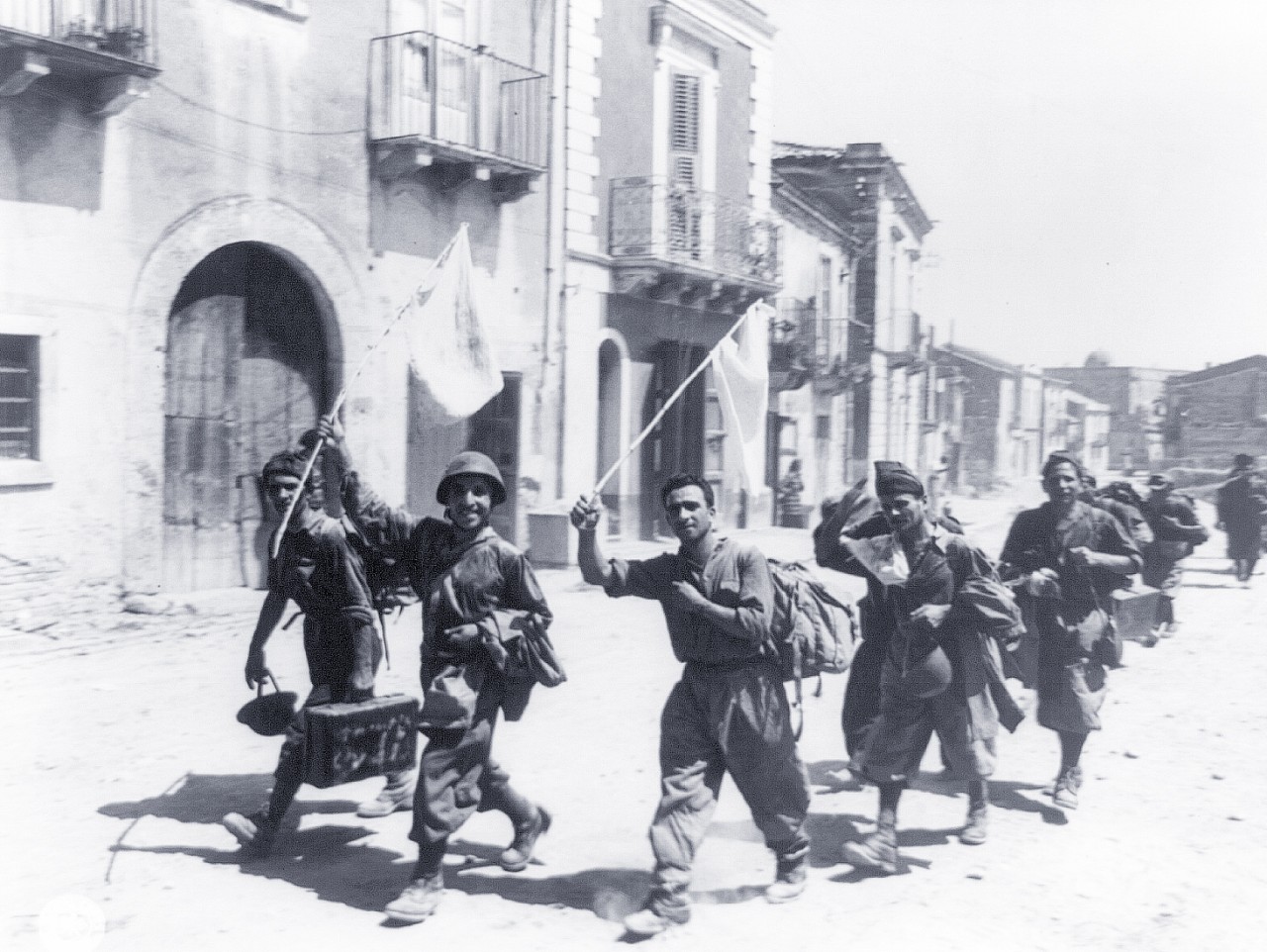 LC-USZ62-98976:   Operation Husky, July-August 1943.  Group of smiling Italian prisoners, trudging into a small town near Messina, Sicily, behind hastily rigged flags of surrender.   U.S. Army Photograph.  Courtesy of the Library of Congress.  (2015/11/13).