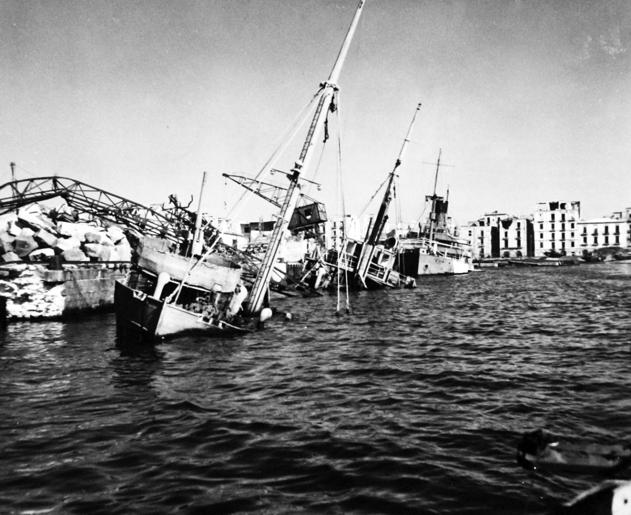 80-G-54365:  Naples, Italy, September 1943.   Damage to the city during that month’s military action.    Shown:  Wrecked ships in the harbor.  Photograph released November 4, 1943.  Official U.S. Navy photograph, now in the collections of the National Archives.  (2016/06/28).