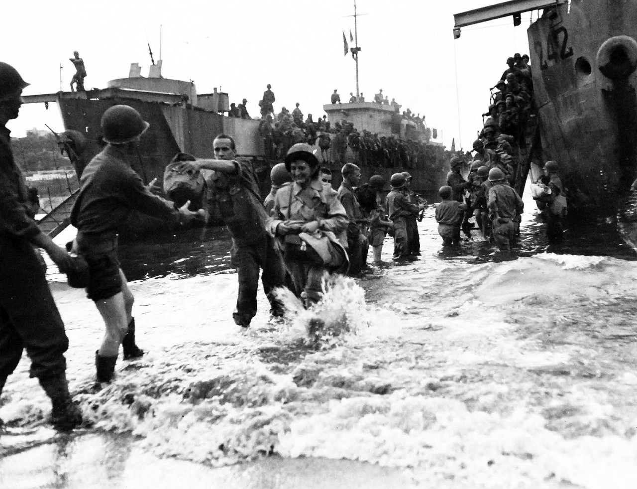 80-G-57146:   Naples, Italy, August 1944.  American nurses being landed as soldiers form a chain to pass their gear onto the beach.  Photograph received August 23, 1944.    Official U.S. Navy Photograph, now in the collections of the National Archives.  (2017/05/02).