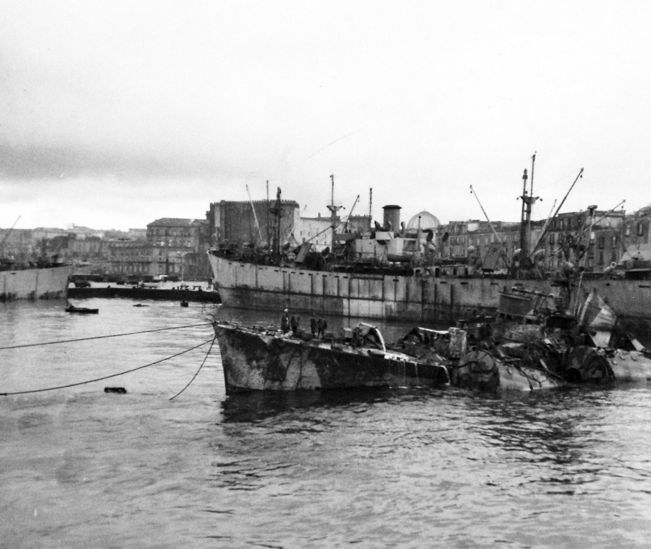 80-G-58285: Naples, Italy, March 1944.    A damaged Italian destroyer ready for towing out to sea for a more practical resting place than the harbor of Naples, Italy.  It had to be raised and held afloat by pontoon tanks.   Photograph released March 2, 1944.  U.S. Navy photograph, now in the collections of the National Archives.  (2016/06/28).