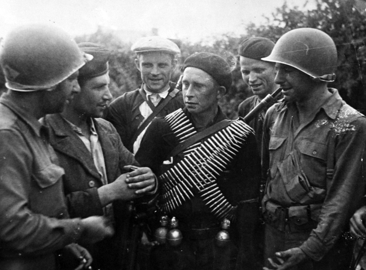 208-AAN-Brest-36356:   Invasion of Southern France, Brest, August-September 1944.  Russian Joins Fight Against Nazis in Brittany.  A Russian who escaped a Nazi labor battalion in Brittany wears crossed cartridge belts and carries hand grenades as he talks with U.S. soldiers and members of the French Forces of the Interior.  Russian soldiers, captured during the enemy drive on Moscow in 1942, broke out of German labor camps and joined the French resisters when U.S. troops closed in on Brest, the beleaguered port on the trip of Brittany Peninsula.   Originally a U.S. Army Signal Corps photograph:  ETO-HQ-44-133441-11, possibly August 1944.   Official U.S. Navy Photograph, now in the collections of the National Archives.  (2015/3/17).    