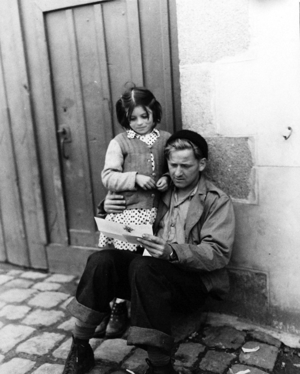 80-G-247092:  Invasion of France, Landerneau, August-September 1944.Mail call for members of small boat crews at Landerneau, France.  French child with Seaman First Class Peter Opyr, photograph received September 1944.  Official U.S. Navy Photograph, now in the collection of the National Archives.  (2014/3/12). 