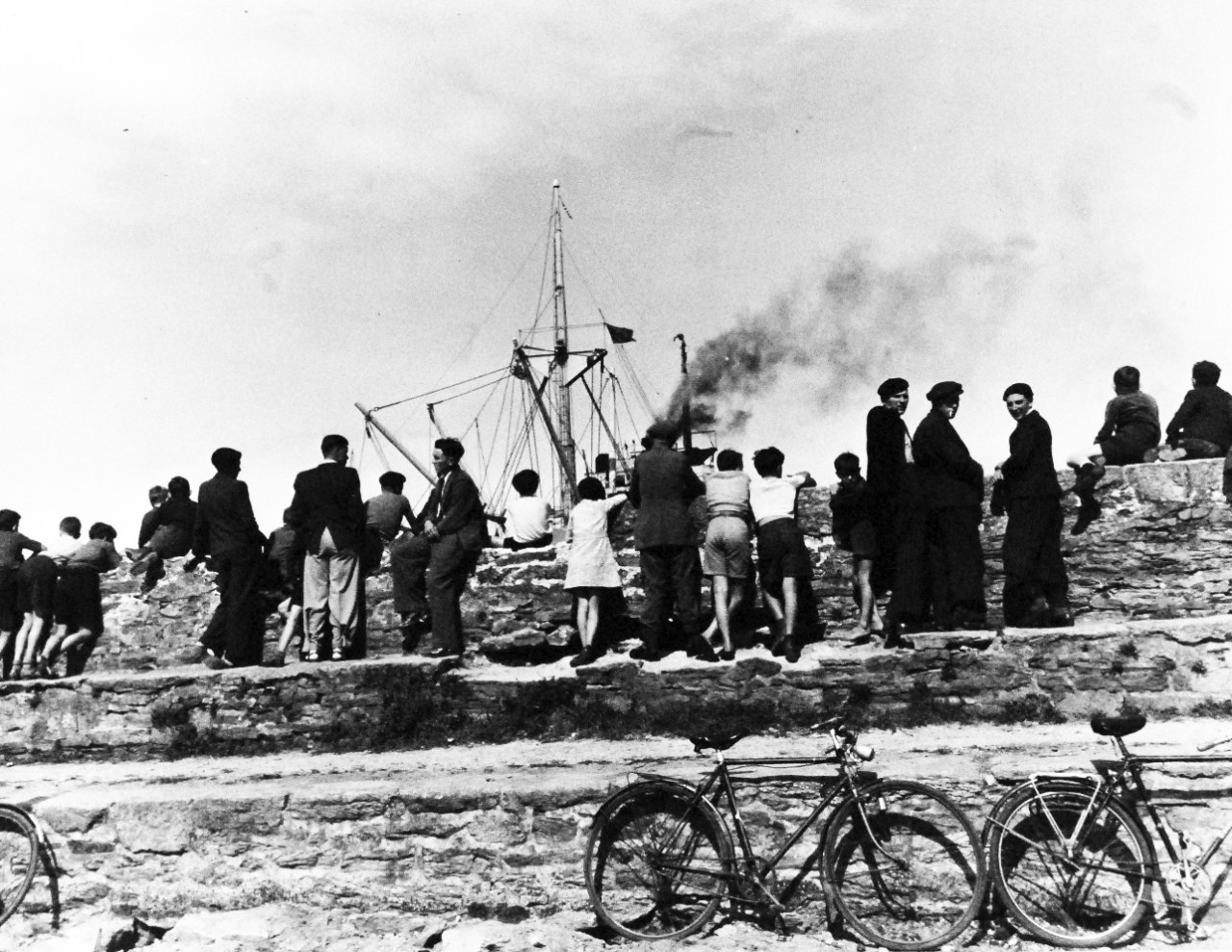 80-G-247132:  Invasion of France, Roscoff, August-September 1944.    French men and boys watch unloading of Dutch coaster, Theseus, at port of Roscoff, France, for battle of Brest, photograph received September 1944.  Official U.S. Navy Photograph, now in the collections of the National Archives.   (2014/3/12).  