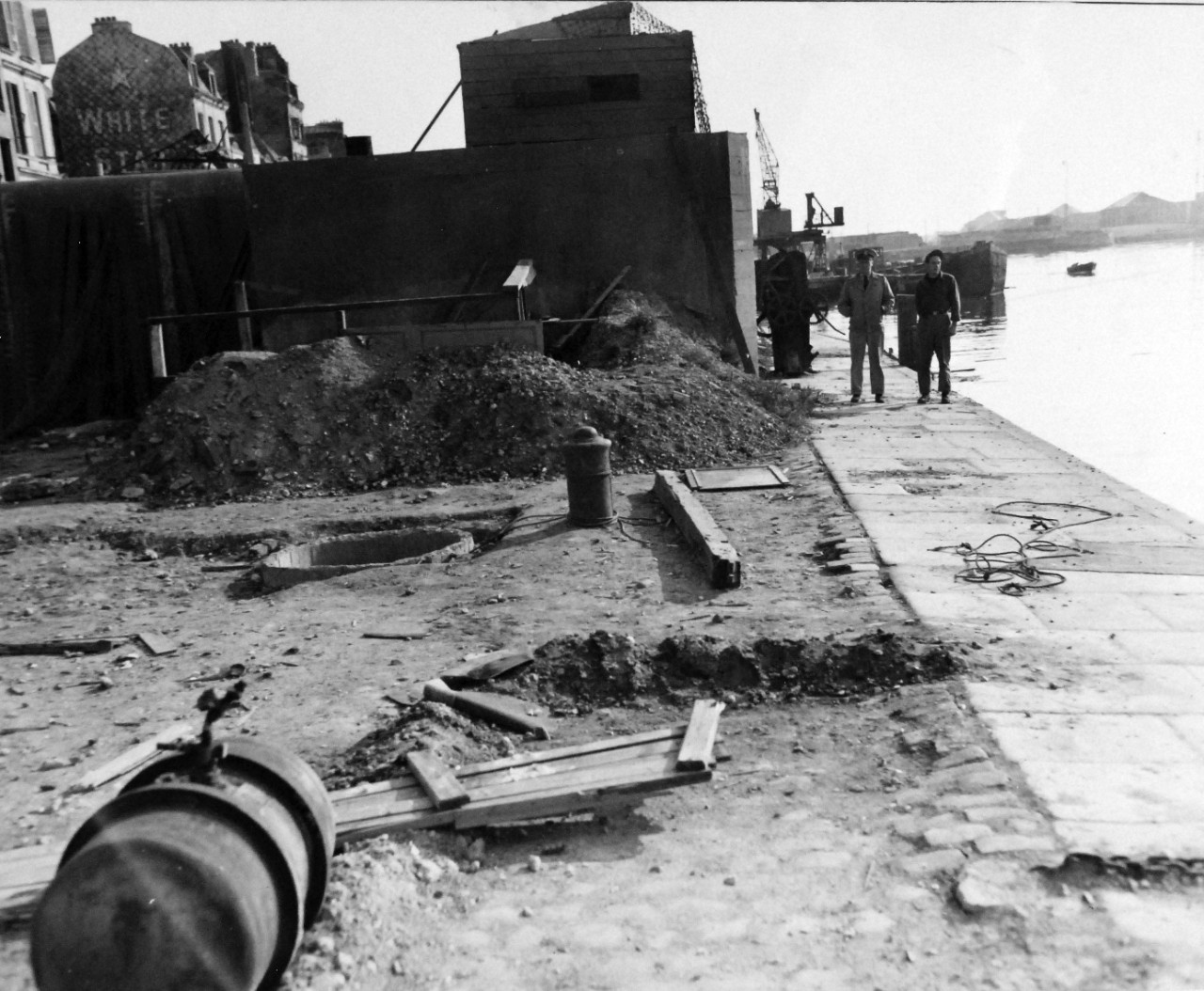 80-G-257400:  Invasion of France, Le Havre, August-September 1944.   Prior to abandoning Le Havre, France, Germans placed demolition charge in well-like hole to destroy part of sea wall to render it useless to Allies.  Tank in foreground is a smokepot that Germans set off to cover harbor areas when Allied planes come over, 28 September 1944.  Official U.S. Navy Photograph, now in the collection of the National Archives.   (2014/10/28).  