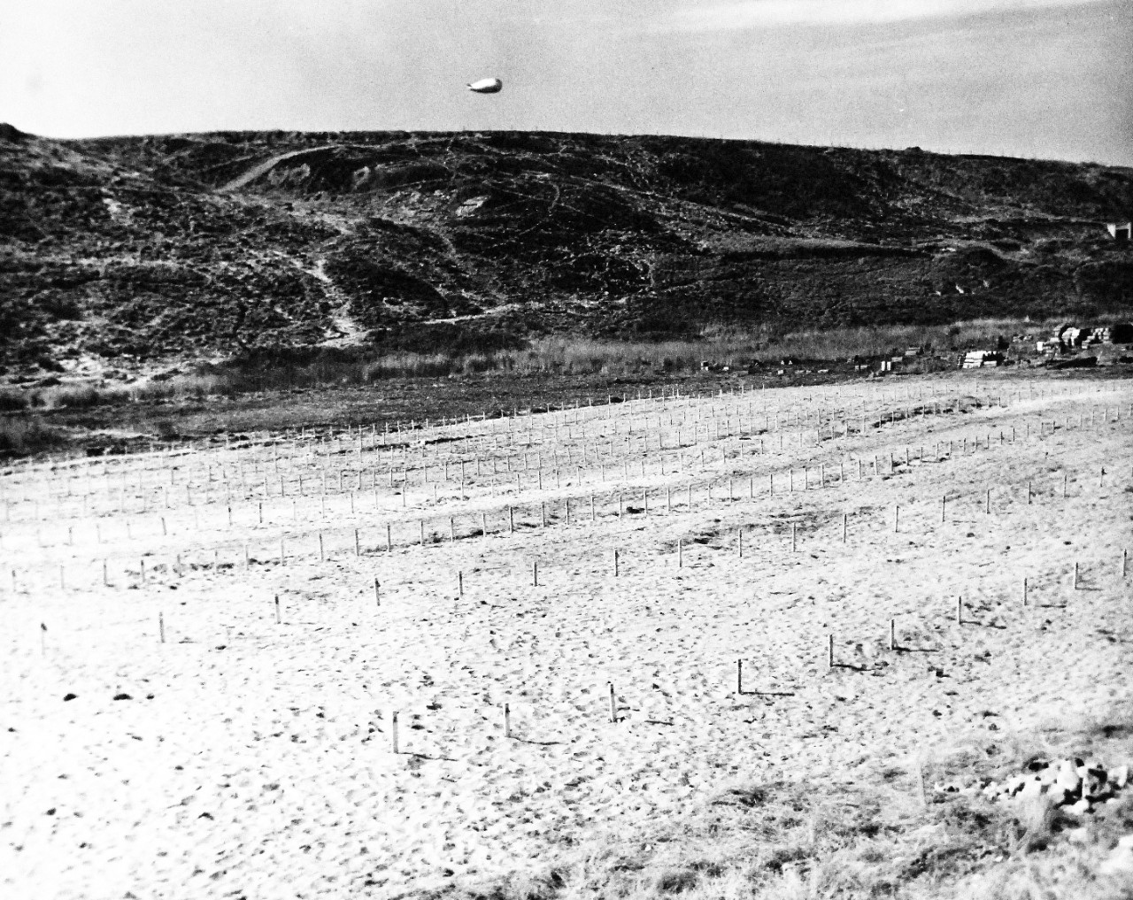 80-G-285224:  Normandy Invasion, June 1944.  Temporary graves of U.S. soldiers on Normandy Beach, France. Note barrage balloon.  Photograph released November 7, 1944.  U.S. Navy photograph, now in the collections of the National Archives.  (2016/03/15).