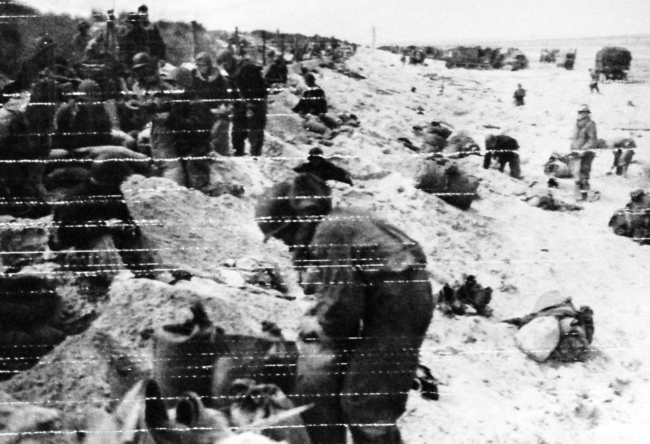 80-G-59413:  Normandy Invasion, June 1944.   “Hitting the Beach” along with U.S. Army troops, members of US Navy beach battalion dig in for their first night ashore on a beachhead on the French coast, released 9 June 1944.  Official U.S. Navy Photograph, now in the collections of the National Archives.    (2014/3/12).   