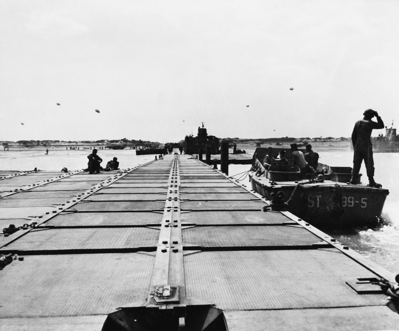 80-G-257325:  Normandy Invasion, Mulberries, 1944.  Pontoon causeway stretching from Allied beachhead in Normandy, France.  LCT’s are unloading.  An LCVP is tied up at right.  Nearer shore, LCT 447 is unloading.  Photograph received 3 October 1944.  Official U.S. Navy Photograph, now in the collections of the National Archives.  (2014/10/28).