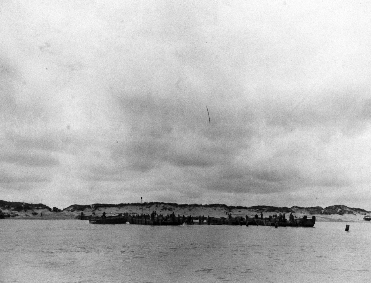 80-G-285134:  Normandy Invasion, Mulberries, June 1944.   The pontoon causeway at “Utah” beach, forming part of the U.S. Mulberry the man-made harbor off coast of France, built to protect landing craft from storms in English Channel.   Photograph released November 7, 1944.  Official U.S. Navy photograph, now in the collections of the National Archives.  (2016/03/15).