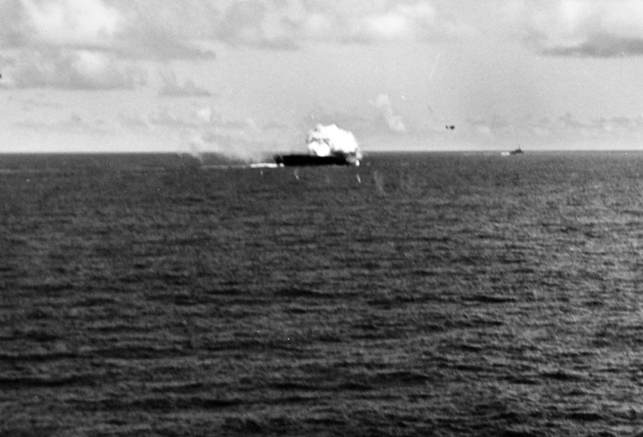 80-G-270614:   USS Suwannee (CVE-27), October 26, 1944.  Crash of Japanese “Zero” kamikaze on USS Suwannee (CVE-27) on the forward flight deck while off Samar.  Note the F6F flying away from the explosion.   Photographed from USS Sangamon (CVE-26).   Official U.S. Navy photograph, now in the collections of the National Archives.  