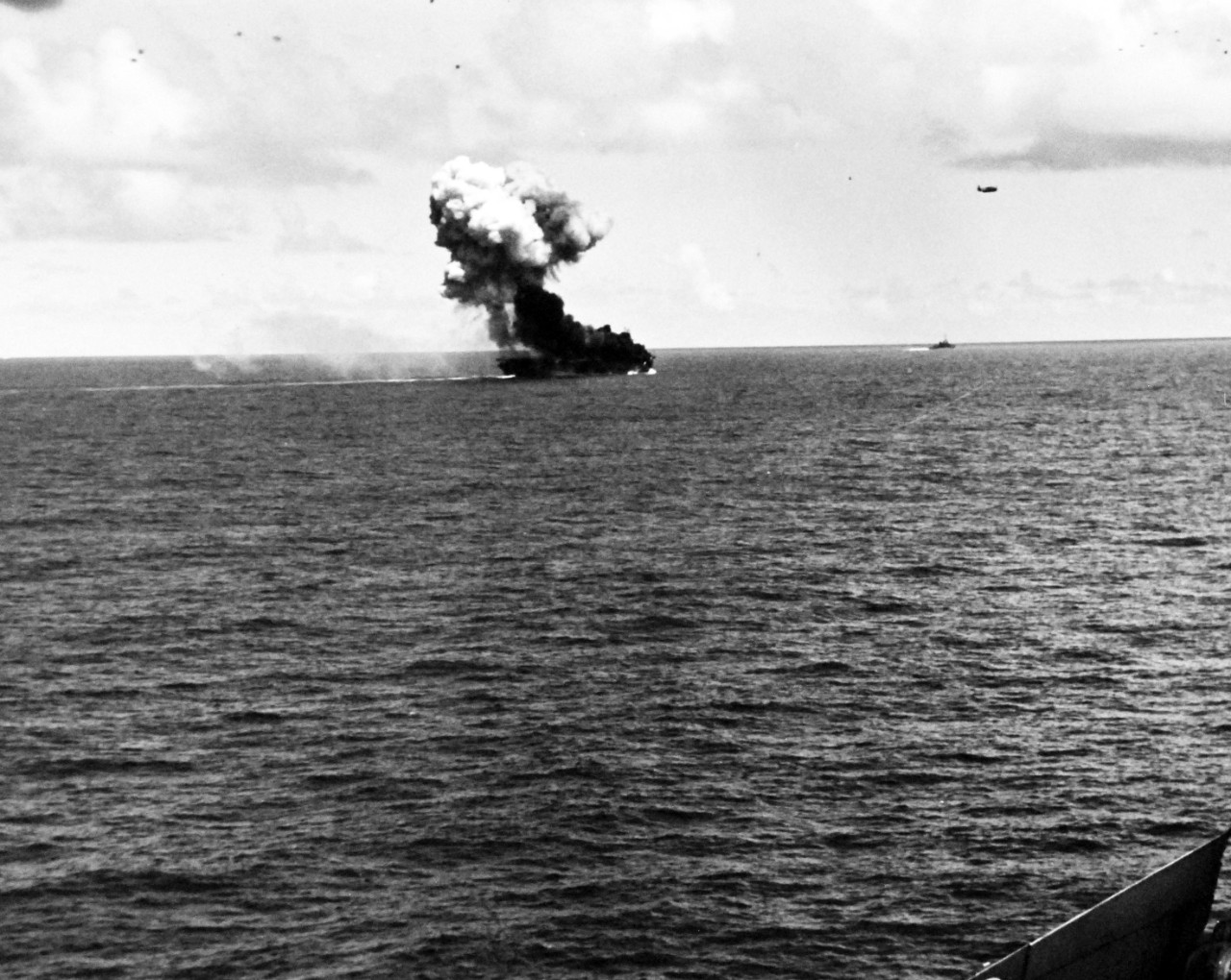 80-G-270619:  USS Suwannee (CVE-27), October 26, 1944.   Fires and explosion on the flight deck of USS Suwannee (CVE-27), resulting from a suicide hit of a Japanese “Zero” near Leyte, Philippines.   The airborne plane is friendly.   Taken from USS Sangamon (CVE-26) at Leyte, Philippines.  Official U.S. Navy photograph, now in the collections of the National Archives.  