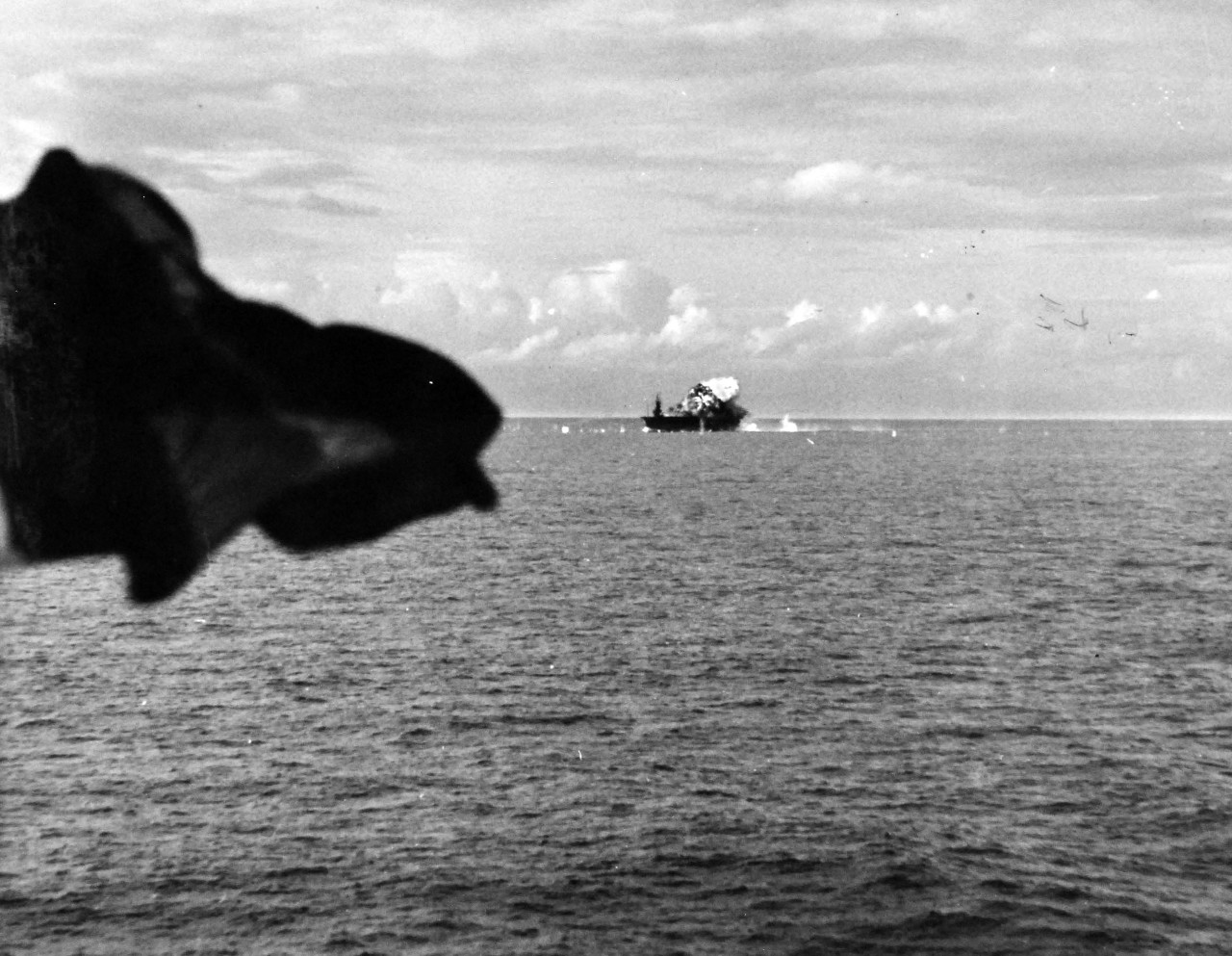 80-G-270663:  USS Santee (CVE-29), October 25, 1944.  Japanese suicide plane attacking USS Santee (CVE-29), hitting after end of flight deck off Leyte Gulf.  As seen from USS Suwannee (CVL-27).  Official U.S. Navy photograph, now in the collections of the National Archives.  