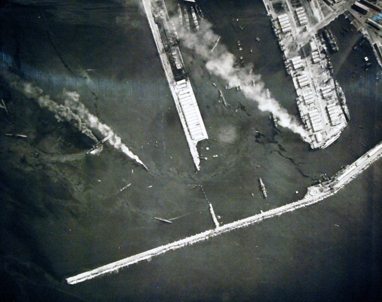 <p>19-LCM-North Africa-5: Naval Battle of Casablanca, November 8-16, 1942. Casablanca, French Morocco. On the morning after the first attack this aerial reconnaissance photograph was taken from a U.S. Navy plane. It shows five burning French ships in the various harbors of Casablanca. One can be seen burning at the end of the large pier (top). The other four are in the outer harbor, ranging from center to left, and in the extreme lower left corner. At the end of the large pier, the French merchant ship Porthos can be seen lying on its side. Photograph released on 1 December 1942.&nbsp;</p>
