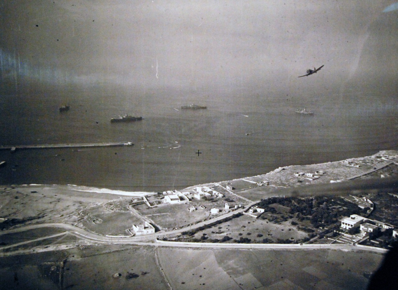 <p>19-LCM-North Africa-6: Naval Battle of Casablanca, November 8-16, 1942. Safi, French Morocco. American transports and landing barges complete operations under the watch eyes of U.S. Navy carrier-based planes. An SBD, Douglas Scout Bomber can be seen in the upper right. Safi lies about 130 miles south of Casablanca on Africa’s west coast. Photograph released 1 December 1942.&nbsp;</p>
