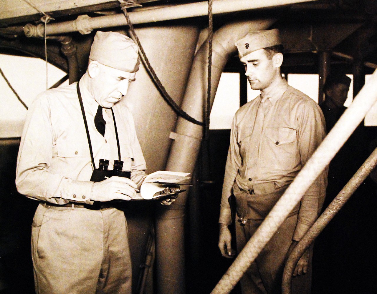 <p>80-G-30399: Operation Torch, November 1942. USS Augusta (CA 31). Rear Admiral J.L. Hall, Jr., Chief of Staff of the Western Naval Task Force, checks a communique.&nbsp;</p>
