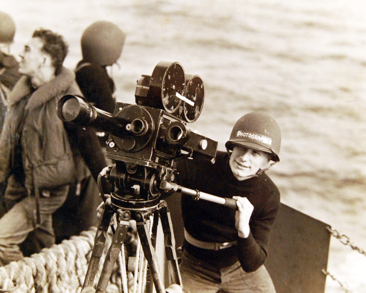 <p>80-G-30315: Operation Torch, November 1942. Photography during the campaign. Shown: Photographer’s Mate 2/C William Wade, USN, trains his movie camera on a group of scout bombers.</p>
