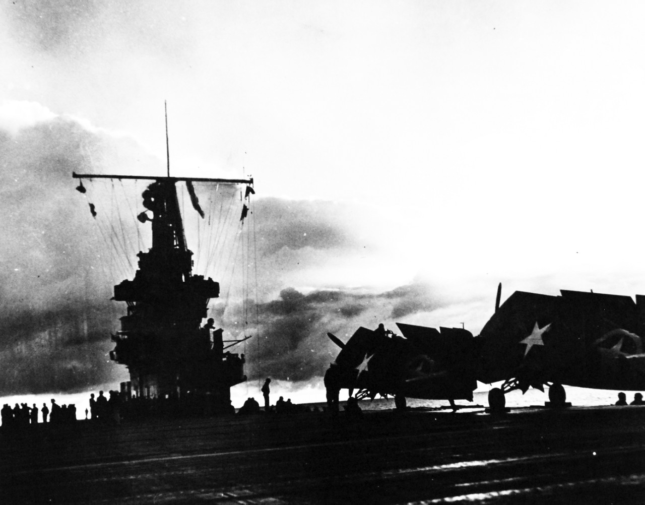 <p>80-G-30356: Operation Torch, November 1942. Sunset over French Morocco on the evening of the day Allied forces invaded North Africa. Dark in the gathering gloom, planes of U.S. aircraft carrier seem to rest beneath their wings on the flight deck of their ship. Photograph released October 27, 1943.&nbsp;</p>
