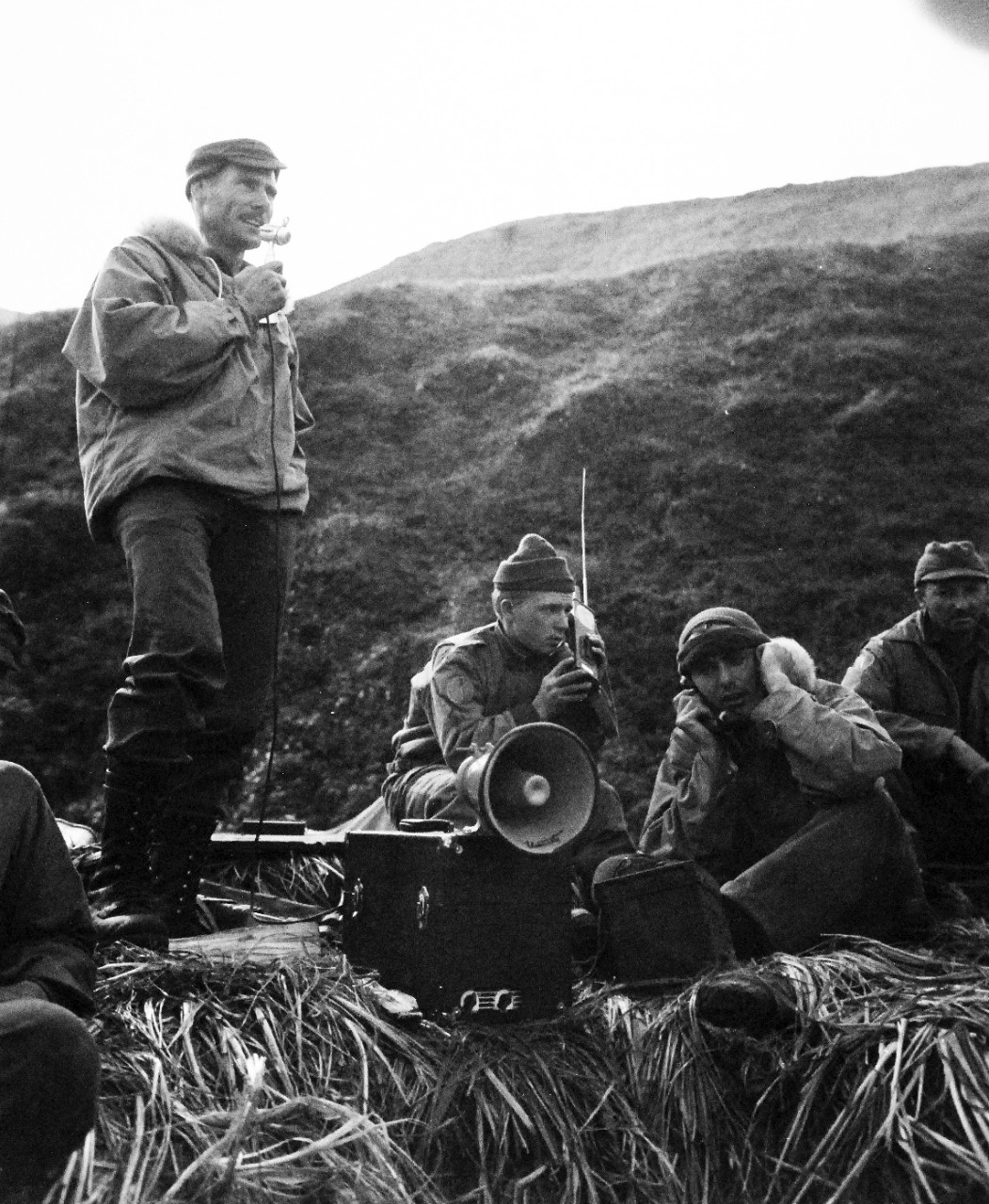 80-G-43534:  Aleutian Islands Campaign, June 1943-August 1943.   Invasion of Kiska Island, August 15-24, 1943.    Members of an observation unit of the vanguard of the joint American-Canadian invading force, following landing at Kiska, Aleutians, talk to their superiors over portable radio.  Photograph released October 29, 1943.   Official U.S. Navy Photograph, now in the collections of the National Archives.    (2015/8/18).