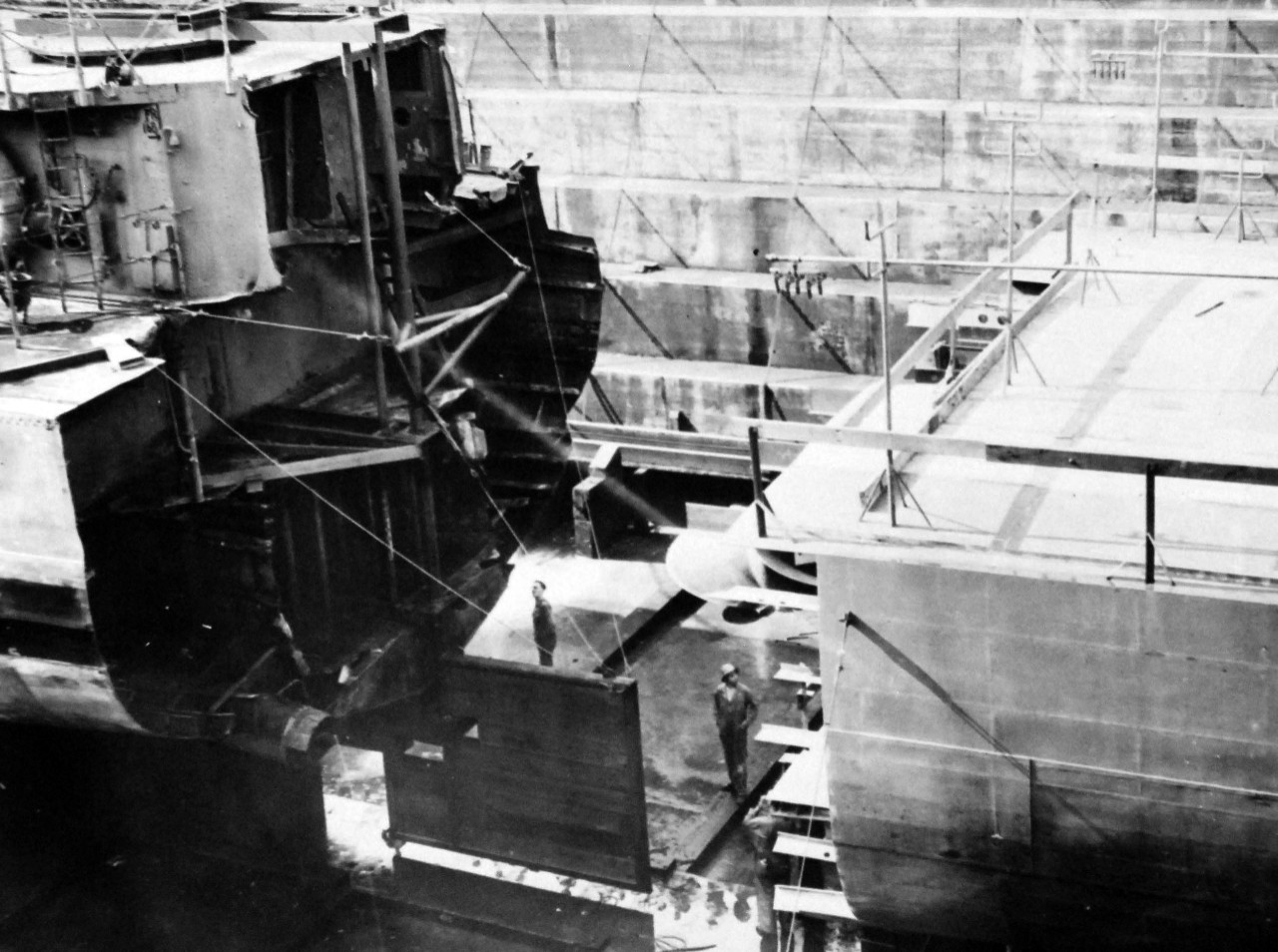 80-G-44452: Aleutian Island Campaign, June 1942-August 1943.    Mine in Alaskan waters blew stern off USS Abner Read  (DD 526). She was brought to Puget Sound Navy Yard, Bremerton, Washington, for repairs.   Temporary repairs were made in the North, so she could be towed to the Navy Yard.   In this picture, she is almost ready to be fitted together.  Photograph released 11 January 1944.  Official U.S. Navy Photograph, now in the collections of the National Archives.  (2014/6/5). 