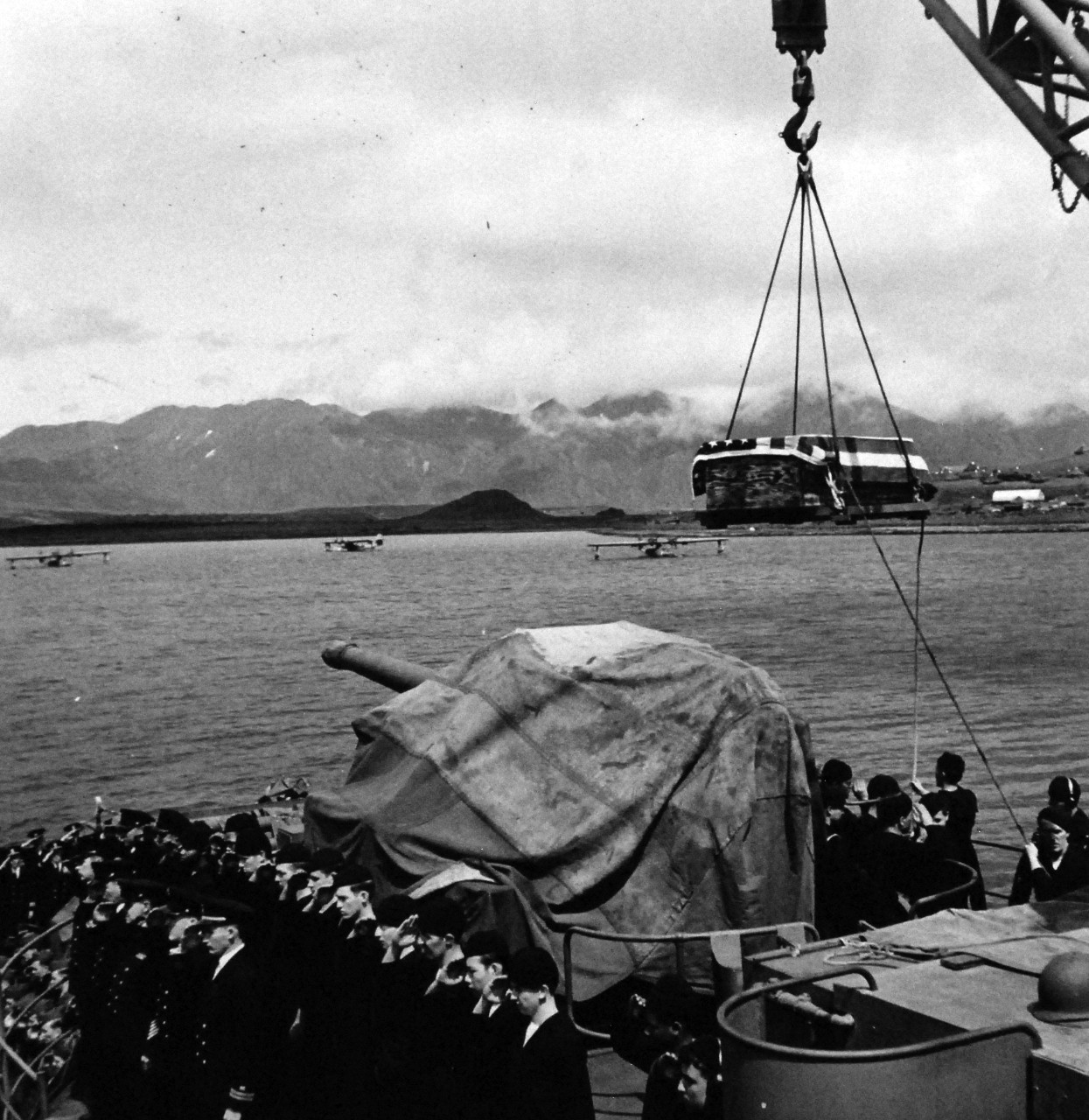80-G-475656:  Aleutian Islands Campaign, June 1942 - August 1943.  Battle of Attu, May 11-29, 1943.  While shipmates salute, flag covered casket of U.S. sailor is lowered into small boat from USS Casco (AVP-12) to be taken to Attu for burial.  Photographed released by the Steichen Photographic Unit:  Lieutenant Commander Horace Bristol, July 1943.  TR-5347.   U.S. Navy photograph, now in the collections of the National Archives.  (2015/11/17).
