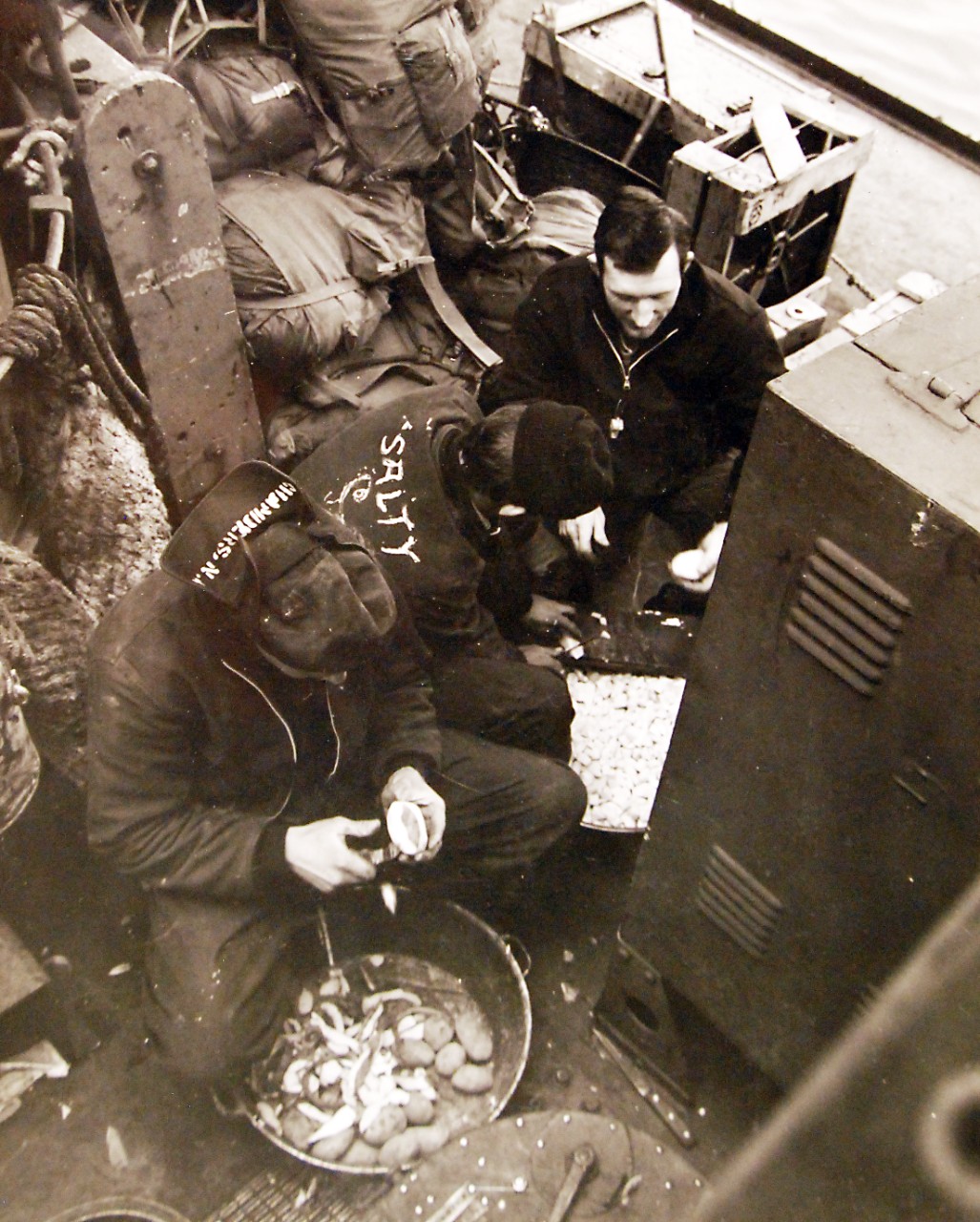 80-G-51004:    Aleutian Islands Campaign, June 1942 - August 1943. Battle for Attu, May 1943.      Peeling potatoes on board an amphibious craft on way to invade Attu.   U.S. Navy Photograph, now in the collections of the National Archives.  (2016/05/10).