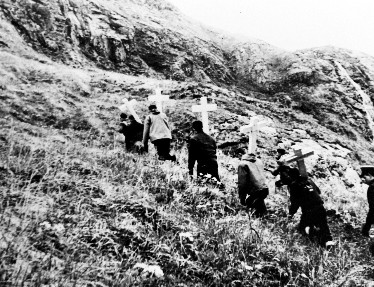 LC-Lot-803-15:  Aleutian Islands Campaign, June 1942 - August 1943.  Battle of Attu, May 11-29, 1943.  Grim anywhere, war has an added starkness in the bleak wilds of the Aleutians.  Upon the living falls not only the sorrowful burden of mourning the dead, but the harrowing task of burying them.   Bearing crosses and shovels, Navy men tail up the barren sides of a mountain to perform the last rites for their comrades.  U.S. Navy photograph, released September 7, 1943.  Photographed through Mylar sleeve. Courtesy of the Library of Congress.    (2015/11/06).
