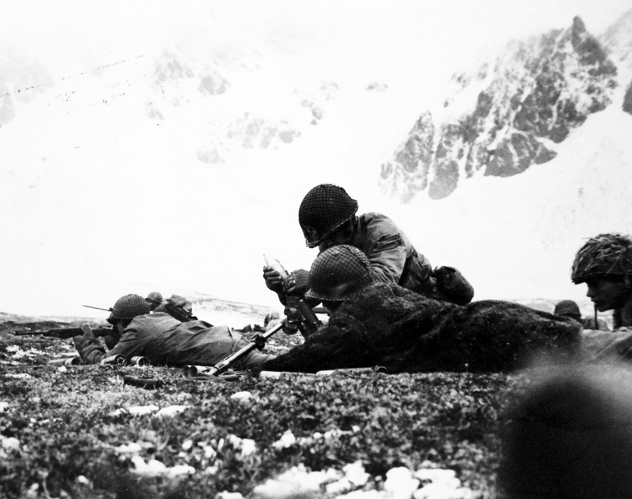 LC-Lot-803-34:  Aleutian Islands Campaign, June 1942 - August 1943.   Allied Landing on Attu Island, May 11 1943.  Tenseness of Battle Grips These Men on Attu Ridge.  High upon Chicagof Ridge overlooking Chicagof Harbor, American soldiers were so intent on their job that the Navy Combat Photograph Unit cameraman didn’t have to worry about “camera muggers.”  The men in the foreground load a shell into a small mortar.  Note the fur jacket worn by the man in the prone position.  It was taken from a dead Japanese.  Chicagof Harbor was the last Japanese stronghold to fall in the fighting on Attu Island in the Aleutians.   U.S. Navy photograph, released July 20, 1943.   Photographed through Mylar sleeve.  Courtesy of the Library of Congress.  (2015/11/06).