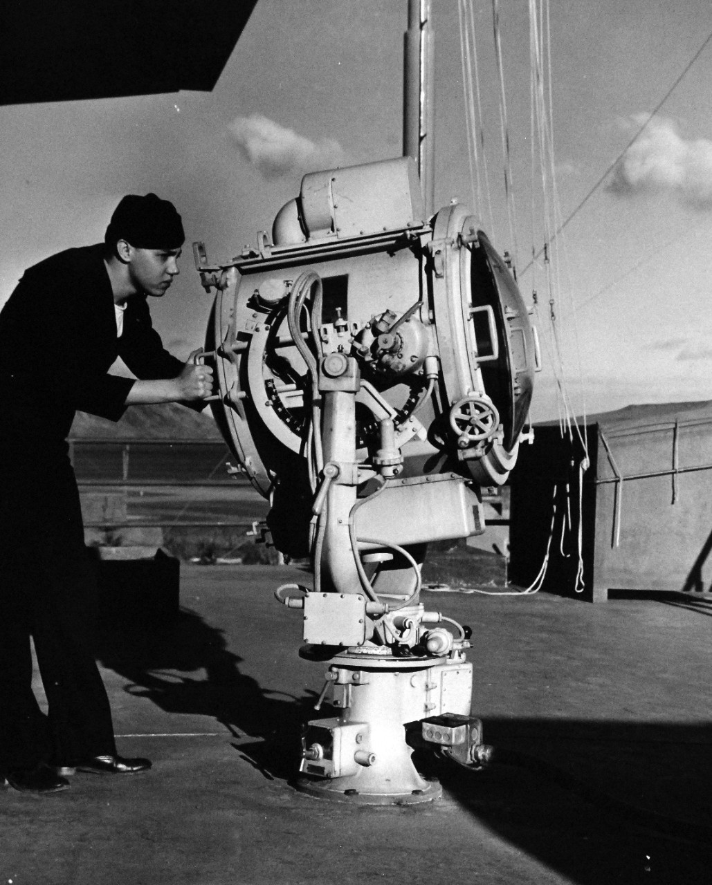80-G-279767:   U.S. Naval Air Station, Kodiak, Alaska, 1943.     QM3/C A. Drank, USN, operating searchlights from atop control tower.  Photograph released October 29, 1943.  U.S. Navy Photograph now in the collections of the National Archives.  (2016/01/19).