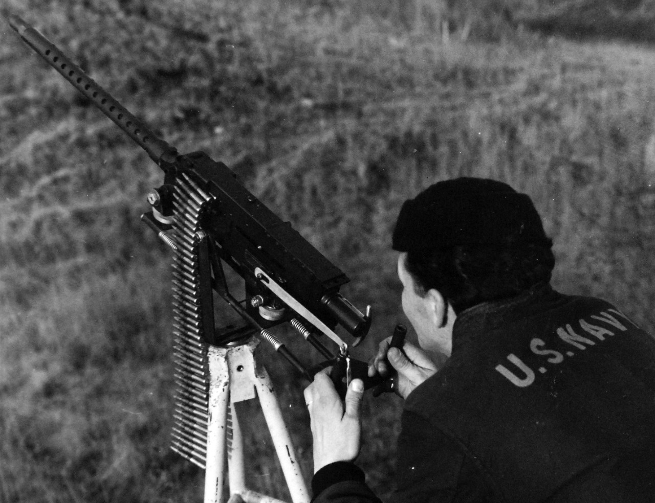 80-G-279813:  U.S. Naval Air Station, Kodiak, Alaska, 1944.   AOM1/C J.C. Mazzie performing fixed test firing of a mount devised by the Petty Officer while at the air station..  The 30 cal. Machine gun mount permits easy test firing.  Photographed by PhoM1/C J.E. Martin, November 6, 1944.  U.S. Navy Photograph now in the collections of the National Archives.  (2016/01/19).