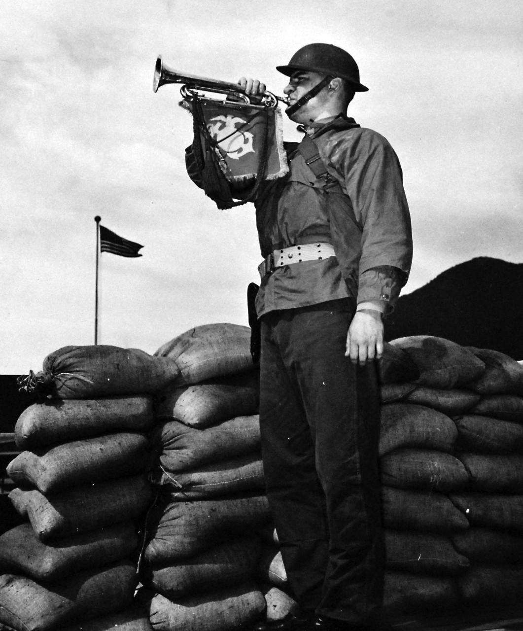 80-G-40995:   Aleutian Islands Campaign, June 1942-August 1943.    From a sandbagged post somewhere on the Alaskan frontier, a U.S. Marine bugler calls his comrades to their stations.   Photograph released March 30, 1943.  Official U.S. Navy Photograph, now in the collections of the National Archives.  (2016/12/20).