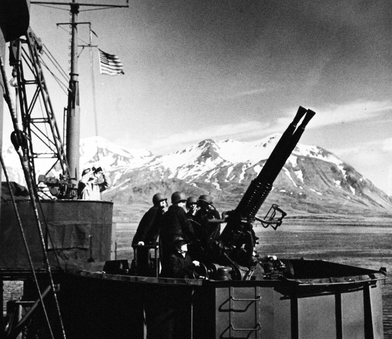 80-G-43596:   Aleutian Islands area, November 1943.    A seaplane tender in Aleutian waters.  Ship’s gun crew trains a 40mm battery on an unidentified aircraft, November 4, 1943.   Official U.S. Navy Photograph, now in the collections of the National Archives.  (2015/8/18).