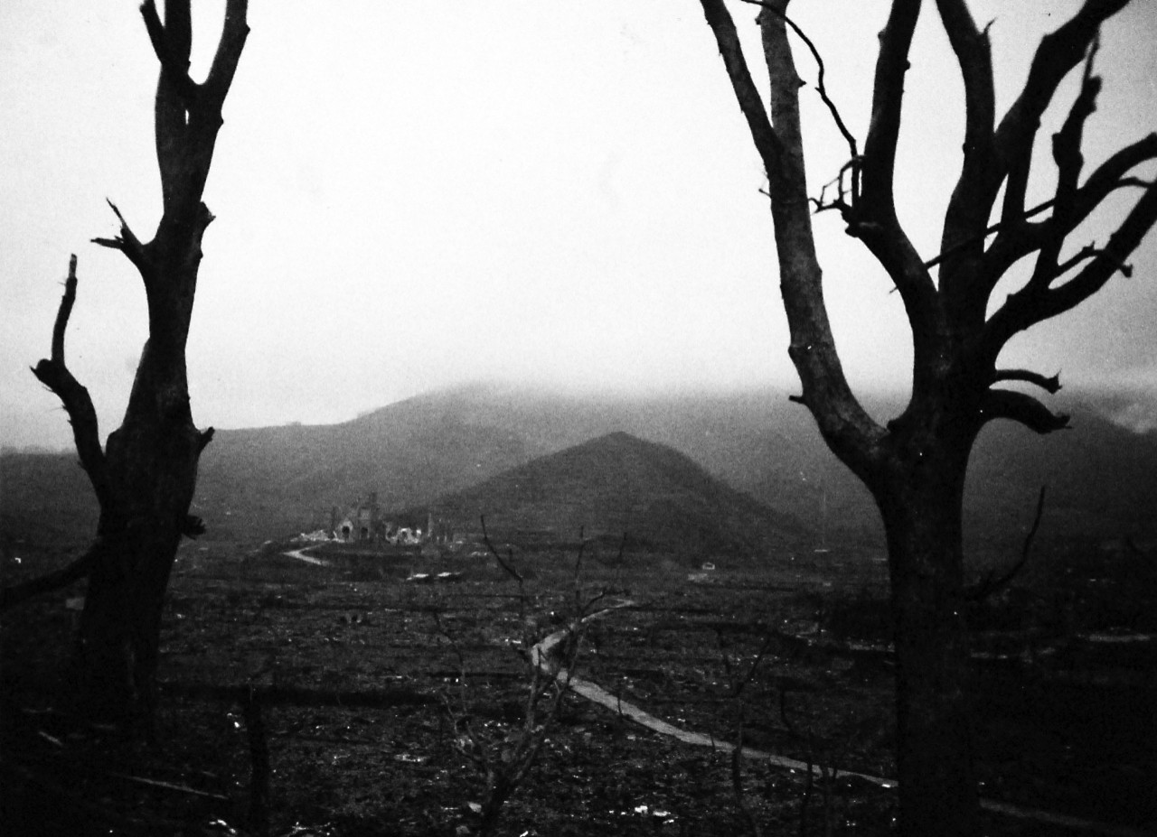 127-GW-1643-137423:   Nagasaki, Japan, 1945.   Utter Desolation – In this valley were hundreds and hundreds of homes, set close together, until the atomic bomb exploded on Nagasaki.  Note the structures half a mile distant, scorched, partly ruined.  Bones of seared human beings were found in this area.  Even the trees were scorched.    Photographed by Goldberg at Nagasaki, Japan, September 16, 1945.        Official U.S. Marine Corps Photograph, now in the collections of the National Archives.  (2016/10/25).