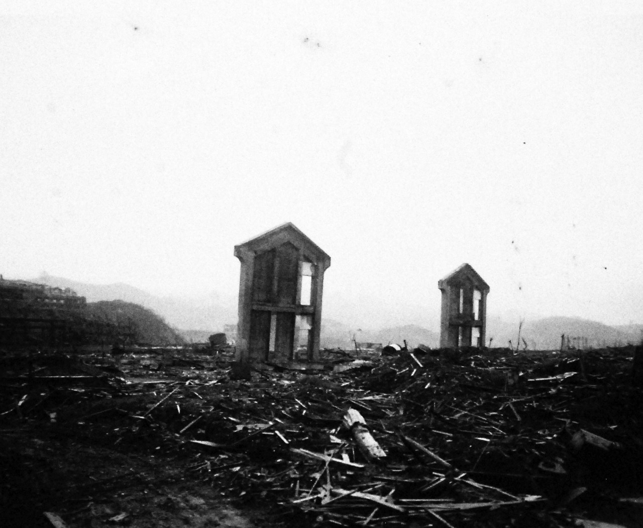 127-GW-1643-137424:     Nagasaki, Japan, 1945.   Two lonely, upright sentinels in the ocean of rubble, where the atomic bomb exploded.  They may have been part of a school, warehouse or industrial plant.     Photographed by September 16, 1945.        Official U.S. Marine Corps Photograph, now in the collections of the National Archives.  (2016/10/25).