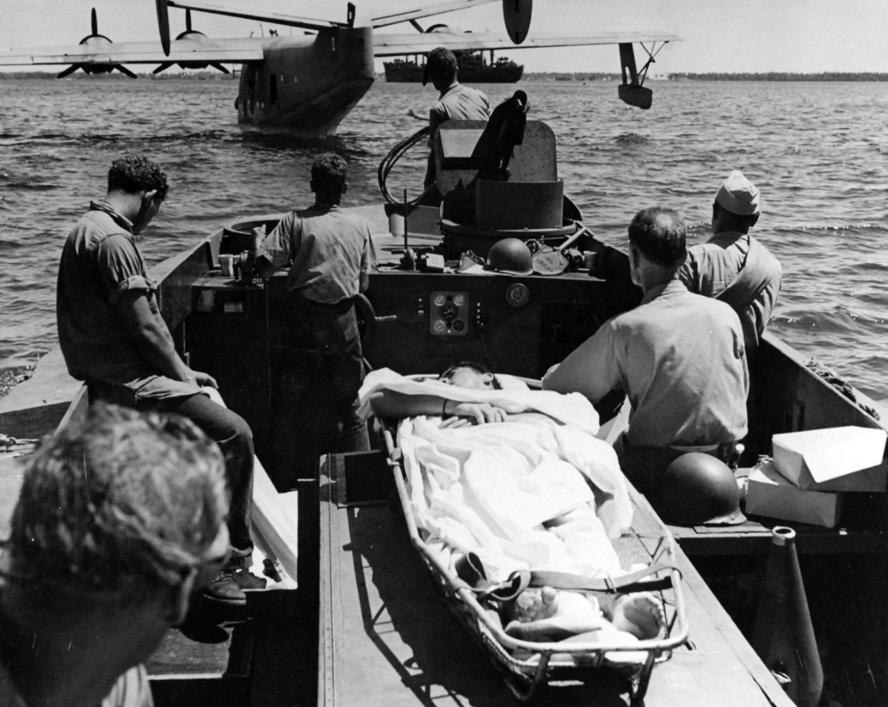80-G-202510:  Operation Galvanic, November 1943.   A PB2Y stands off Makin Island in the Gilberts during the attack, November 20-21, 1943 as a landing boat carrying a wounded soldier comes up to unload its human cargo.  The plane flew wounded from the atoll to the hospital.  Official U.S. Navy Photograph, now in the collections of the National Archives.  (2018/02/21).  