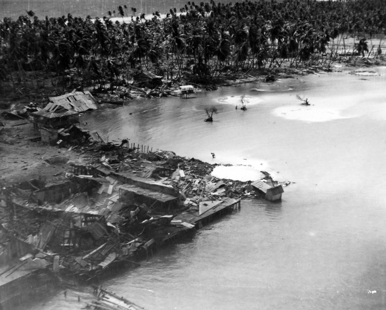 80-G-202520:  Operation Galvanic, November 1943.   Buildings on the wharf on Butaritari Island, Makin, after being leveled by aerial bombardment preceding its capture, November 21, 1943.  Note the large carter on the tip of the wharf.     Official U.S. Navy Photograph, now in the collections of the National Archives.  (2018/02/21).  