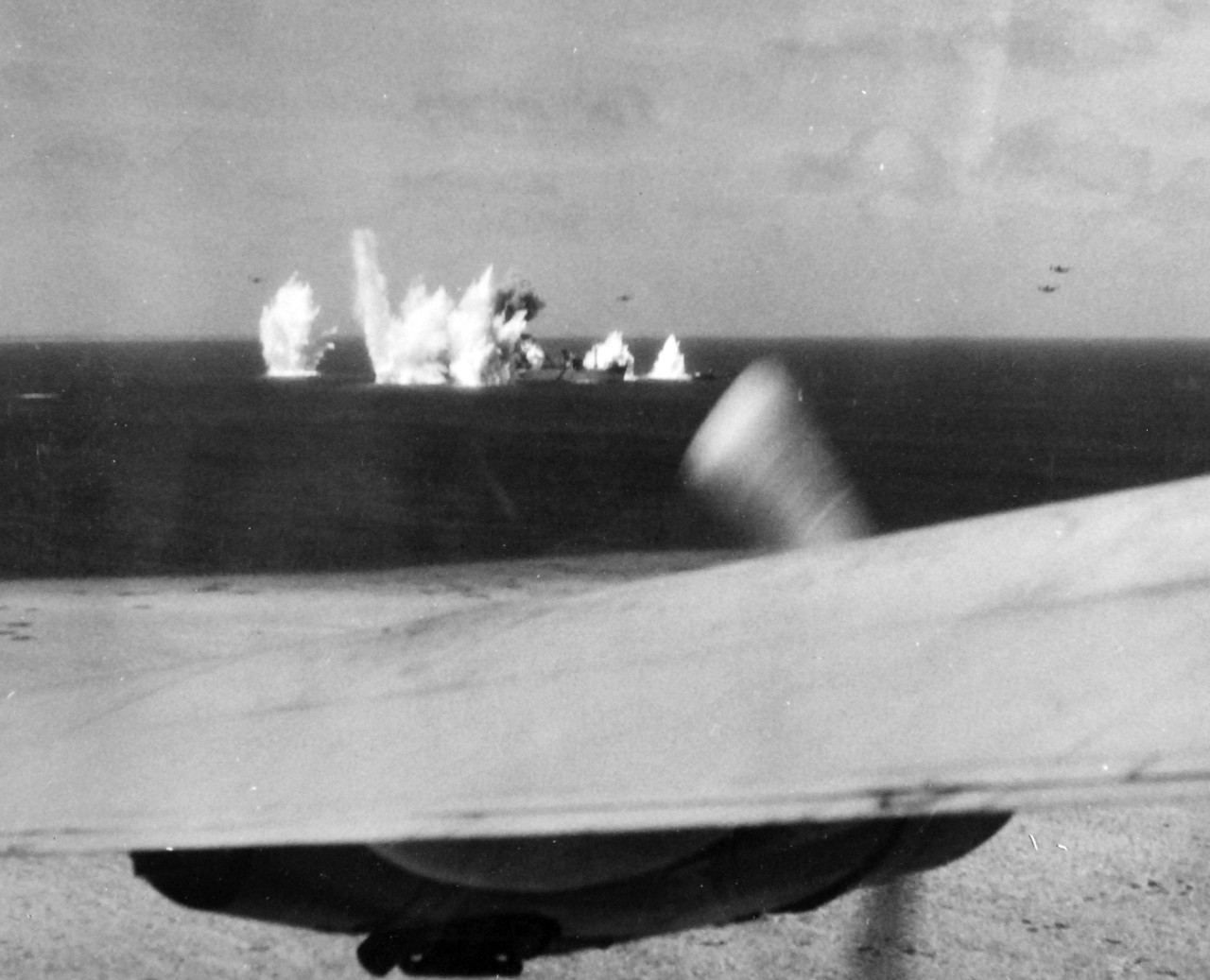 80-G-208532:   Pre-Raid Bombardment of Kwajalein Island, January 12, 1944.    Bombing of Japanese merchant ships at Kwajalein Atoll, Marshall Islands by Bombing Squadron One Hundred Eight (VB-108), January 12, 1944.    Official U.S. Navy Photograph, now in the collections of the National Archives.  (2017/06/27).