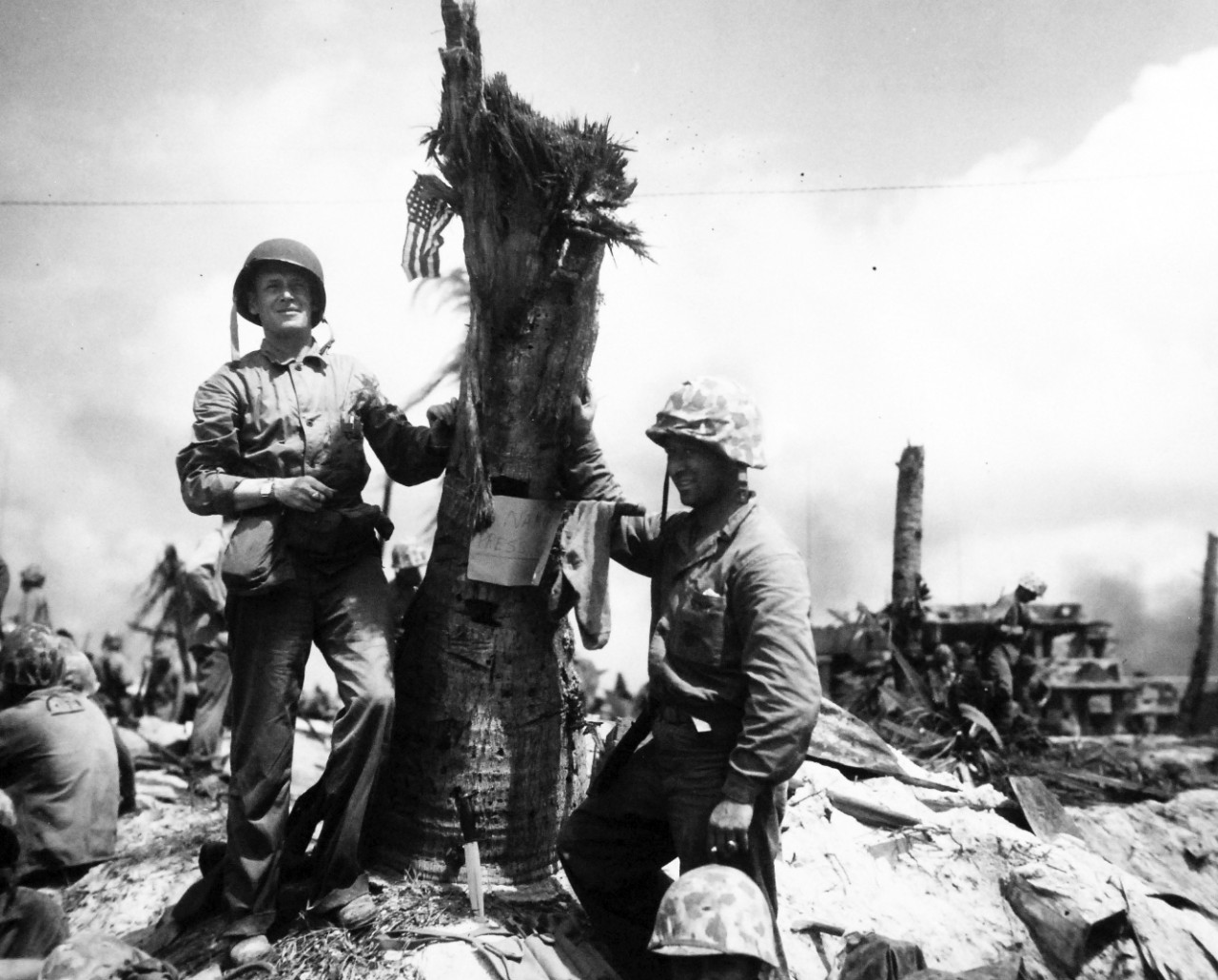 80-G-208987:  Operation Flintlock, January-February 1944.   Fourth Marine Division attack on Roi Island, Kwajalein Atoll, Marshall Islands, February 2, 1944.   Shown:  Lieutenant Colonel Donald L. Dickson puts up flag on cocoanut stump. Sign says Namur Press Office.  On right is Staff Sergeant Martin Kivel, a Marine Corps Combat Correspondent.    Official U.S. Navy photograph, now in the collections of the National Archives.  (2017/07/25).  